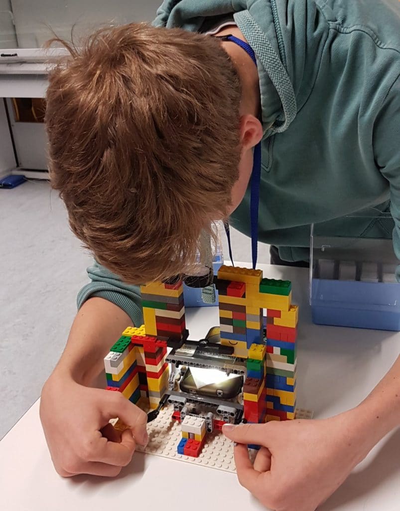 Student using a Lego microscope that they built as part of the CAST challenge