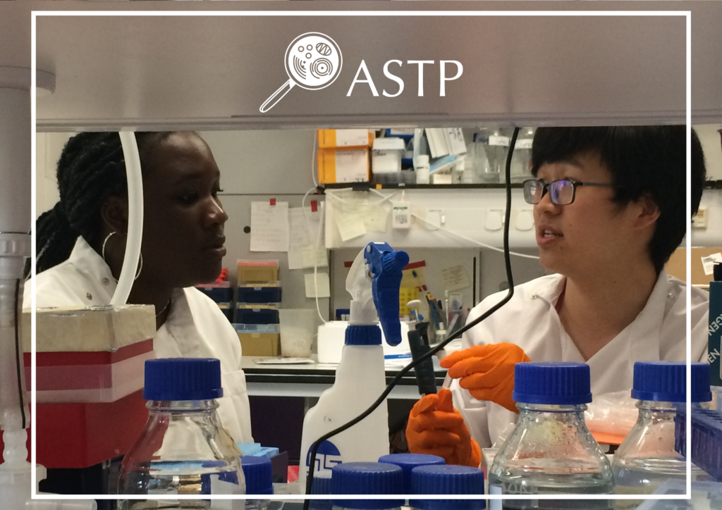 Student and researcher talking in in the lab with the ASTP logo and a white line border