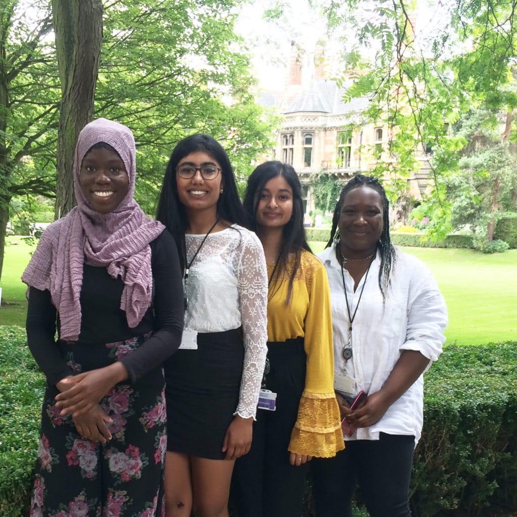Four students smiling in a group photo at Pembroke College