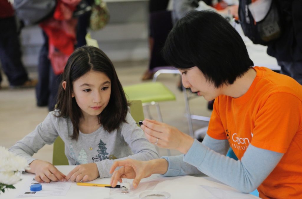 A scientist engaging with a child at a festival event