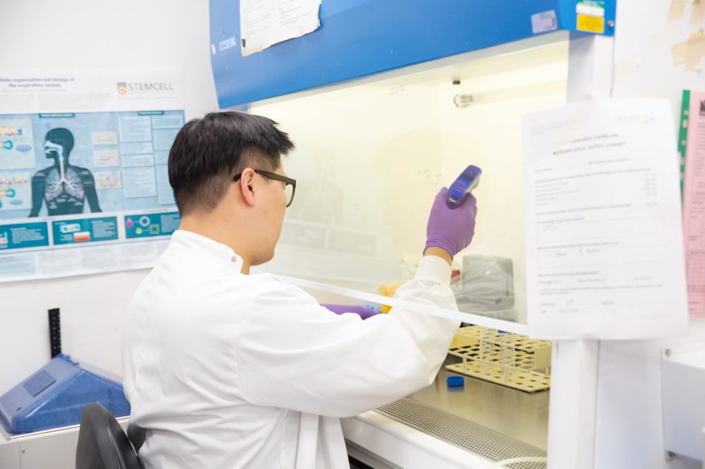 Kyungtae Lim in the Rawlins lab working at the tissue culture cabinet